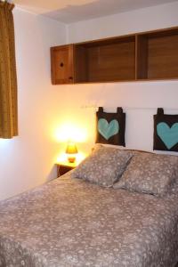 een slaapkamer met een bed met twee harten aan de muur bij Les Chalets D'arrondaz - 4 Pièces pour 8 Personnes 03 in Modane