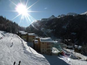een skigebied met mensen die skiën op een besneeuwde helling bij Les Chalets D'arrondaz - 4 Pièces pour 8 Personnes 03 in Modane
