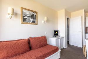 uma sala de estar com um sofá e uma televisão em Résidence Le Thabor - maeva Home - Appartement 2 Pièces 5 Personnes - Sél 794 em Le Désert