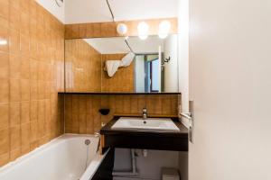 a bathroom with a sink and a tub and a mirror at Résidence Quartier Falaise - maeva Home - Appartement 2 pièces 7 personnes - Sélection MAE-9894 in Avoriaz