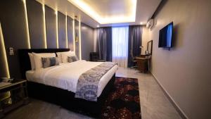 Habitación de hotel con cama grande y TV en Blue Apple Hotel, en Lekki