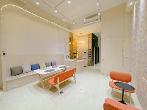 Enjoy Homestay في آنبينغ: غرفة معيشة مع طاولة وكراسي وأريكة