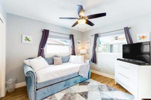 uma sala de estar com um sofá azul e uma televisão de ecrã plano em Let's go to the Beach! em Clearwater