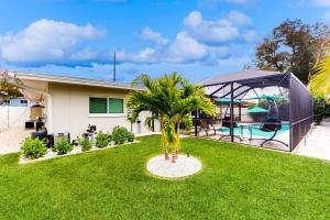 uma casa com um jardim com uma palmeira no quintal em Let's go to the Beach! em Clearwater