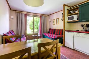 uma cozinha e sala de estar com uma mesa e um sofá em Résidence L'Alpaga - maeva Home - Studio 4 personnes - Budget 514 em La Salle Les Alpes