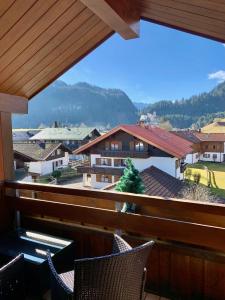 einen Balkon mit Stühlen und Stadtblick in der Unterkunft Ferienwohnung Edelweiß mit Bergbahn unlimited in Obermaiselstein