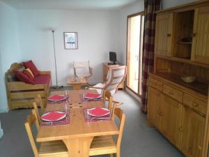 uma sala de jantar com uma mesa com pratos vermelhos em Les Chalets D'arrondaz - 3 Pièces pour 6 Personnes 38 em Modane