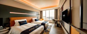Una cama o camas en una habitación de Mustel Hotel Knowledge City Guangzhou