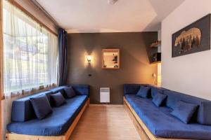 a living room with blue couches and a large window at Résidence LA TRAVERSE - Appartement TRAVERSE 10 pour 4 Personnes 32 in Les Coches