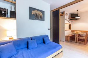 a blue couch in a living room with a table at Résidence LA TRAVERSE - Appartement TRAVERSE 10 pour 4 Personnes 32 in Les Coches