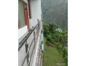 uma varanda de uma casa com vista para uma montanha em Hotel The Narendra Orchid, Phata em Phata