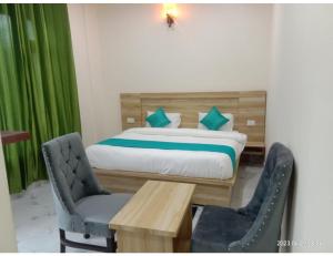 Hotel The Narendra Orchid, Phata في Phata: غرفة نوم بسرير وطاولة وكراسي