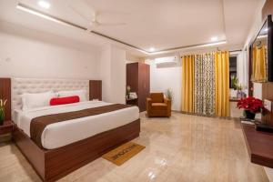 1 dormitorio con 1 cama y 1 silla en una habitación en Rainbow Tower Hotel Airport Road en Hyderabad