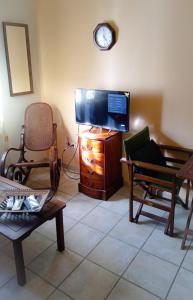 a living room with a flat screen tv and chairs at Derveni Seaside Apartments "Groundfloor" in Derveni