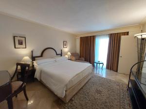 a bedroom with a large bed and a living room at Pearl Continental Hotel, Rawalpindi in Rawalpindi