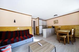 uma sala de estar com um sofá e uma mesa em Résidence L'Alpaga - maeva Home - Appartement 2 pièces 7 personnes - Séle 434 em La Salle Les Alpes