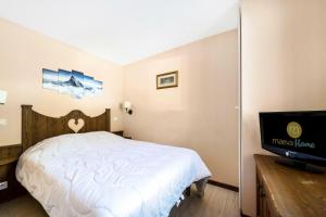 um quarto com uma cama e uma televisão de ecrã plano em Résidence L'Alpaga - maeva Home - Appartement 2 pièces 7 personnes - Séle 434 em La Salle Les Alpes