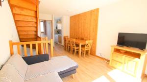 un salon avec un canapé, une télévision et une table dans l'établissement Résidence Parc Aux Etoiles - CH28PAE - CHALET TRIPLEX T5 - TERRASSE - 7 PERS MAE-2104, à Narreyroux