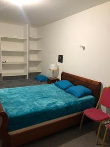 een slaapkamer met een bed met blauwe kussens bij Aladin resort in Bouconvillers