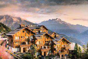 a large wooden house on top of a mountain at Résidence Le Hameau des Ecrins - maeva Home - Appartement 2 Pièces 4 Perso 064 in Puy-Saint-Vincent