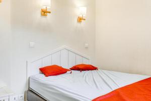 a bed with two red pillows on top of it at Résidence Quartier Falaise - maeva Home - Appartement 2 Pièces 5 Personnes - Sélection MAE-6534 in Avoriaz