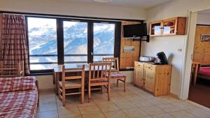 a room with a table and chairs and a view of a mountain at Résidence Pendine - Pièces 954 in Les Prés