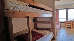 two bunk beds in a room with a table at Résidence Pendine - Pièces 954 in Les Prés
