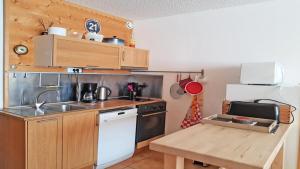 a small kitchen with a sink and a stove at Résidence Podium - Studio pour 5 Personnes 384 in Les Prés