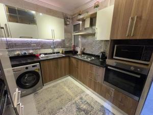 a kitchen with wooden cabinets and a washer and dryer at Luxurious apartment in cairo in Cairo