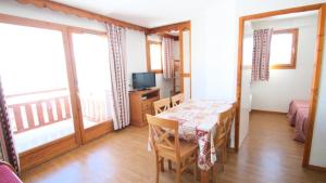 une salle à manger avec une table et un balcon dans l'établissement Résidence Parc Aux Etoiles - C311PAE - APPARTEMENT 1 CHAMBRE ET 1 CABINE, BALCON MAE-2414, à Narreyroux