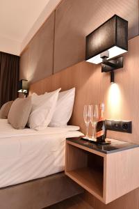 a hotel room with a bed with wine glasses on a table at Flatbook - City Center SPA Apartments Deo Plaza in Gdańsk