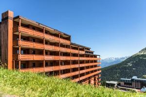 un edificio al lado de una colina en Résidence Les Hauts Bois - maeva Home - Appartement 3 Pièces 8 Personnes - 034, en Aime La Plagne