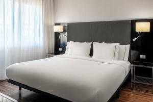 1 cama blanca grande en una habitación de hotel en AC Hotel Madrid Feria by Marriott, en Madrid