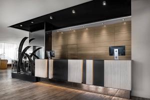 a lobby with a reception desk with a tv on it at AC Hotel Madrid Feria by Marriott in Madrid