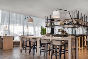 a dining room with a bar with stools at AC Hotel Madrid Feria by Marriott in Madrid