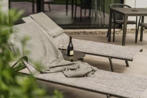 a chair with a book and a bottle of wine at Agriturismo Insolito in Terlano +53 photos