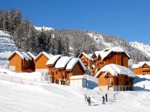 um grupo de pessoas em pé na neve perto de um alojamento de turismo selvagem em Résidence Parc Aux Etoiles - 4 Pièces pour 7 Personnes 504 em Narreyroux