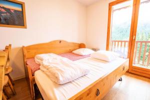 una camera da letto con un letto con lenzuola bianche e una finestra di Résidence Belvedere Busseroles - 3 Pièces pour 6 Personnes 193071 a Modane