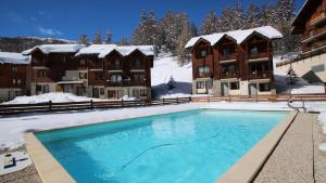 une piscine sous la neige devant un hôtel dans l'établissement Résidence Parc Aux Etoiles - C306PAE - APPARTEMENT 3 CHAMBRES, BALCON MAE-2744, à Narreyroux