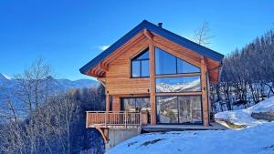 a log cabin in the snow with a large window at Chalet - Chalets pour 12 Personnes 644 in Les Prés