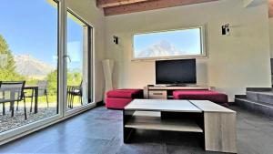 a living room with a couch and a tv and a balcony at Chalet - Chalets pour 10 Personnes 774 in Les Prés