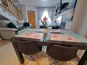 a dining table and chairs in a living room at Nice 3 bedroom Duplex Cabo Roig in Orihuela Costa