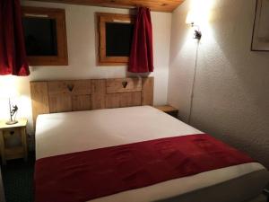 a bedroom with a bed with a red blanket on it at Résidence Le Hameau du Sauget - maeva Home - Appartement 2 pièces 6 person 334 in La Plagne Tarentaise