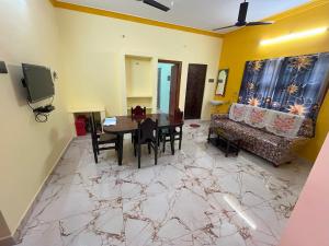 a living room with a table and a couch at Sai Ayush Homestay in Kumbakonam