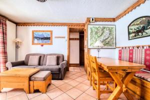 ein Wohnzimmer mit einem Sofa und einem Tisch in der Unterkunft Résidence La Ginabelle - maeva Home - Appartement 3 pièces 6 personnes - P 604 in Chamonix-Mont-Blanc