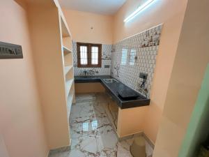 La salle de bains est pourvue d'un lavabo et d'un miroir. dans l'établissement Sai Ayush Homestay, à Kumbakonam