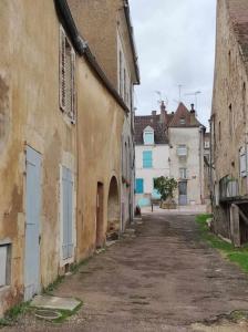 an empty alley in an old city with buildings at La Loupière in Avallon