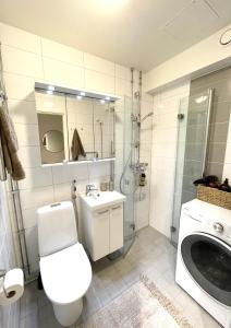 uma casa de banho com um WC, um lavatório e um chuveiro em Seaside apt with parking space, close to metro (6mins from city centre) em Helsinque