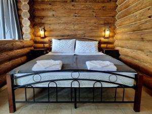 um quarto com uma cama num chalé de madeira em къщи за гости Под звездите em Pamporovo
