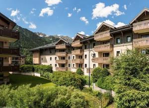 eine Gruppe von Apartmentgebäuden mit einem Rasenplatz in der Unterkunft Résidence La Ginabelle - maeva Home - Appartement 3 pièces 6 personnes - P 904 in Chamonix-Mont-Blanc